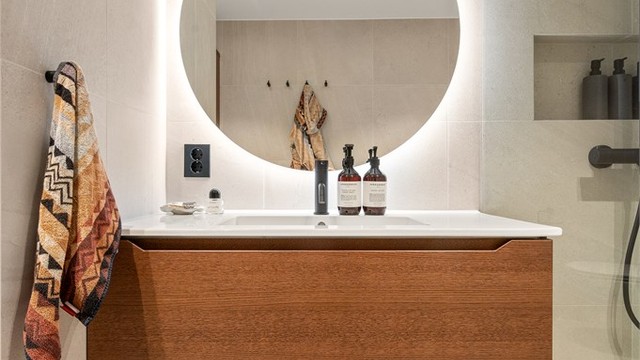 Innredningen fra Linnbad har en servant nedfelt i skuffeseksjon og et elegant, bakbelyst speil.