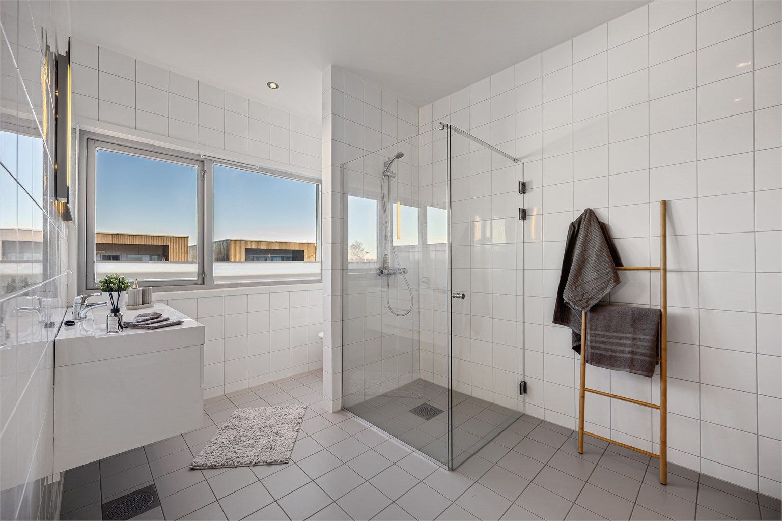 Badet er helfliset og har elektrisk gulvvarme for økt komfort. Baderomsinnredningen fra Aubo har en vegghengt servant med skuffer.