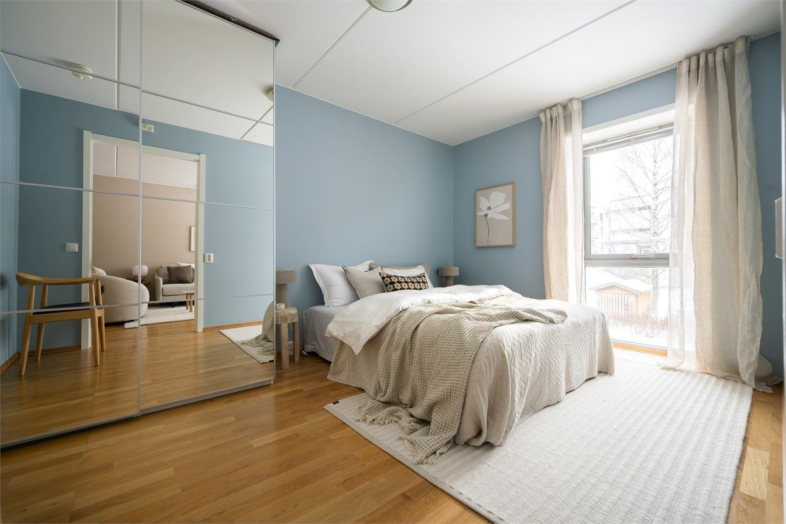 Leiligheten har et stort soverom med skyvedørsgarderobe med speilfronter. Legg merke til det store vinduet. Foto: Martine Eren Jacobsen.