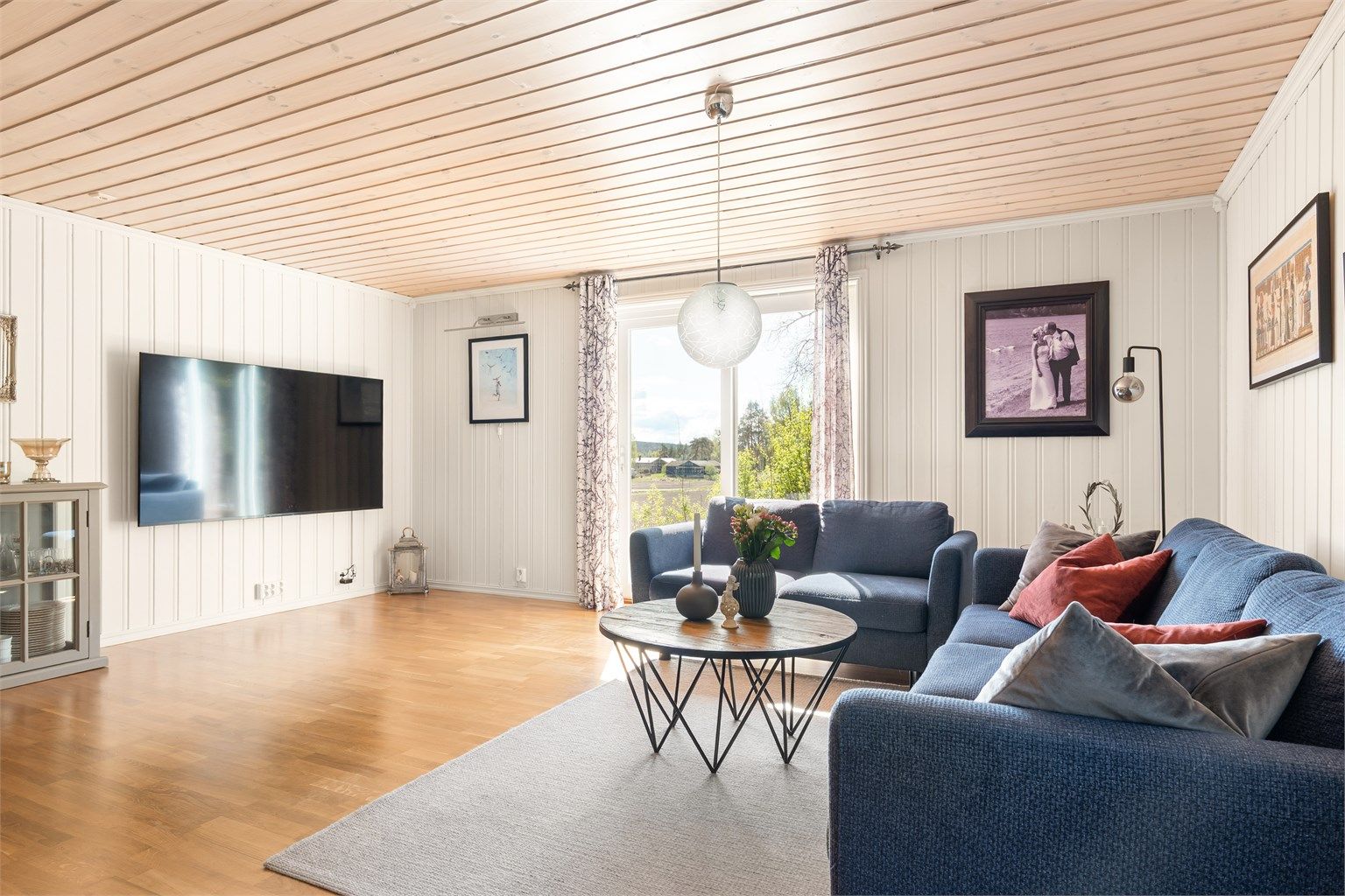 Skyve-/hevedør mot sør slipper solen inn til stuen og gir utsikt til det bølgende åkerlandskapet.