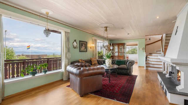 Stua er et stort og vakkert rom på hele 53 kvm, med et blikkfang en peis på den ene siden og fjordutsikten på den andre.