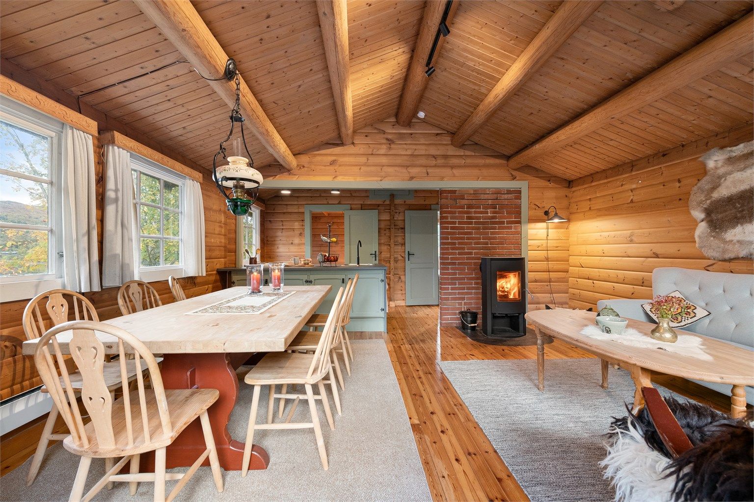 Romslig stue med plass til både sofagruppe og langbord.