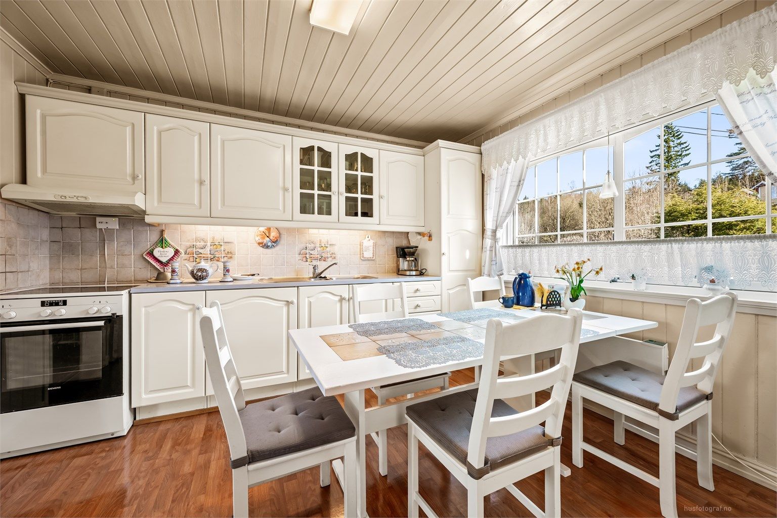 Kjøkkeninnredning fra 1989 med profilerte fronter, laminatbenkeplate og fliser over benken.