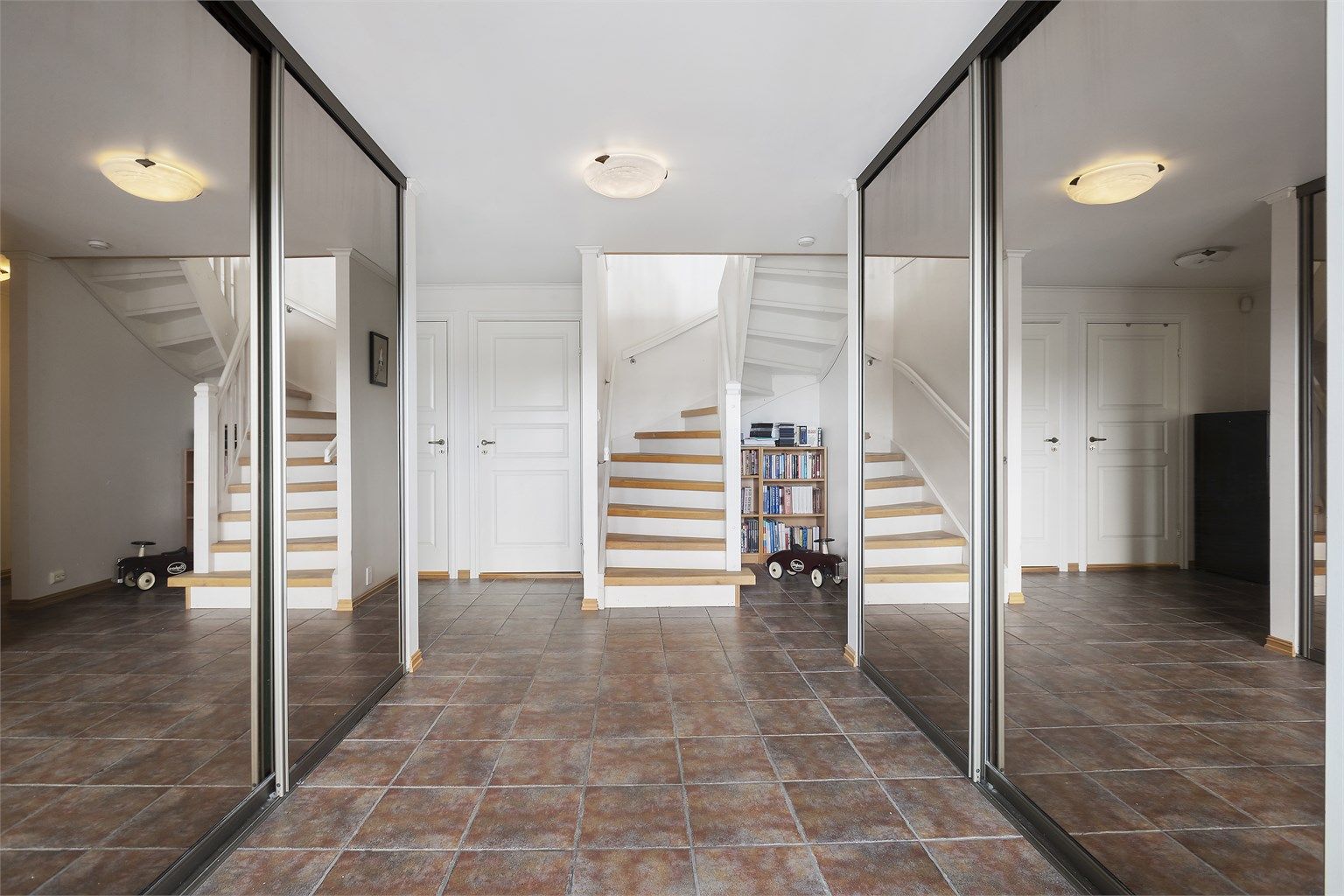 Man kommer inn i en romslig, flislagt entré med dobbel skyvedørsgarderobe