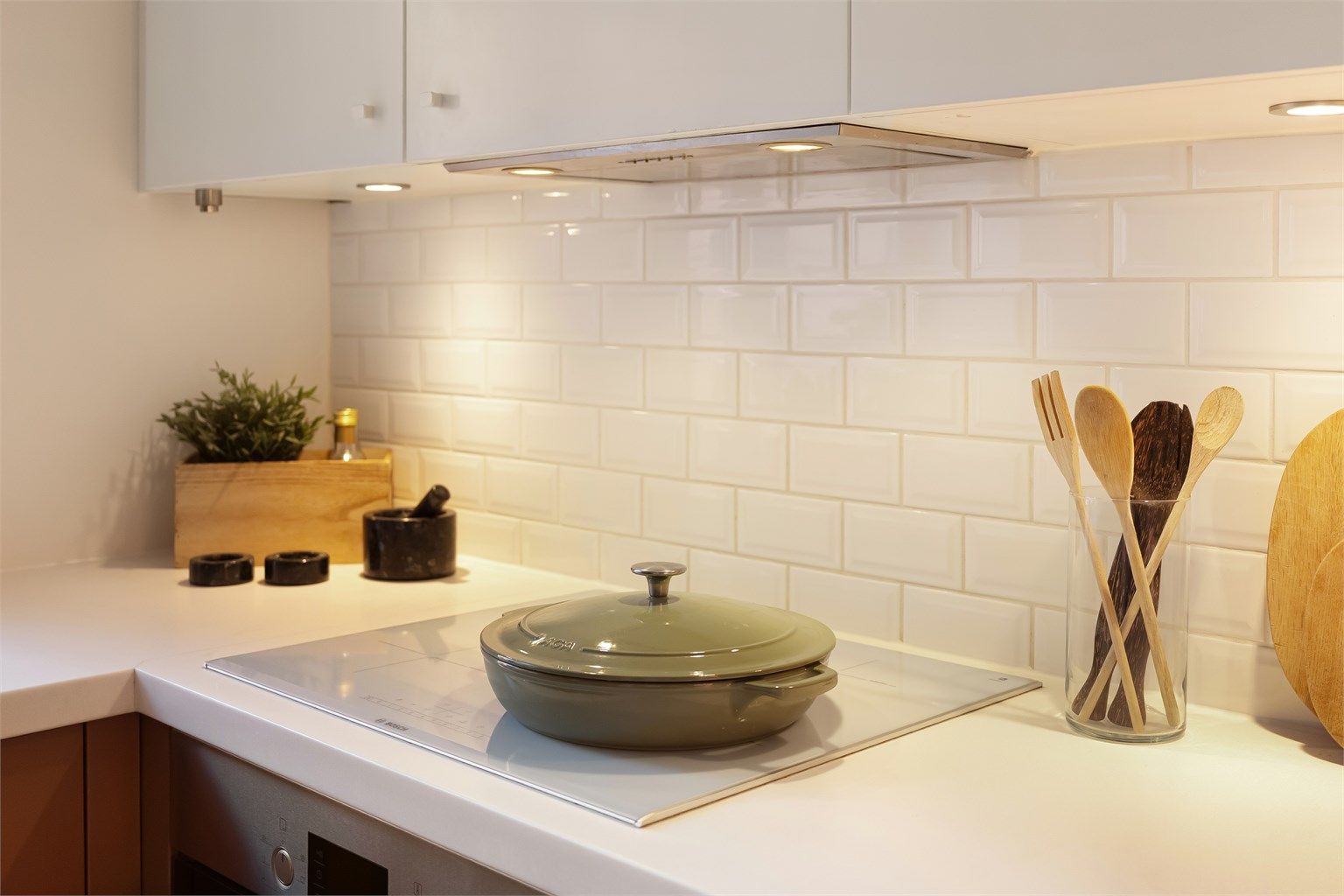 Kjøkkenet er utstyrt med integrerte hvitevarer fra Bosch og kullfilterventilator over kokeplassen. Kjøleskapet er frittstående.