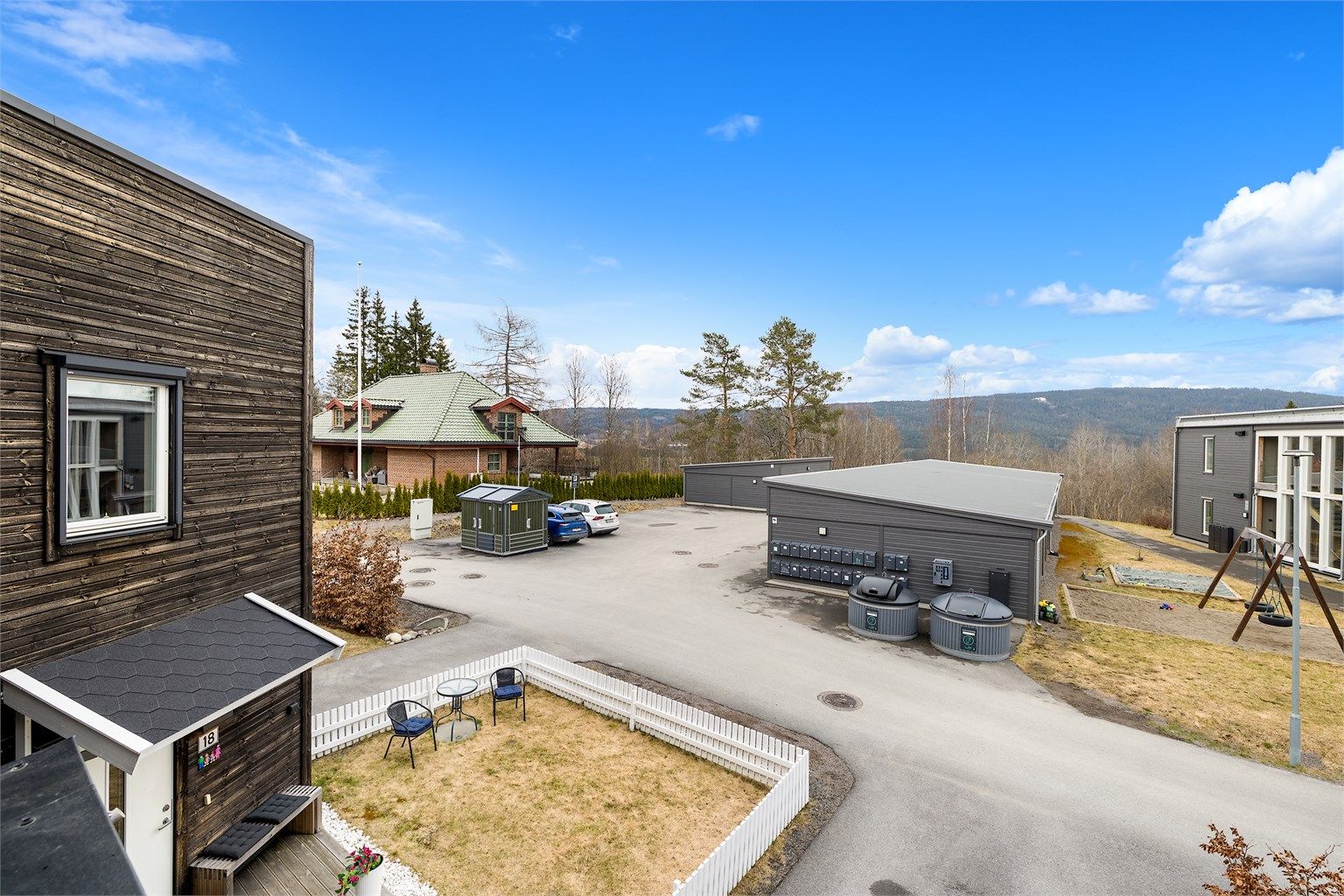 Åpent fellesområde med parkering og lekeplass