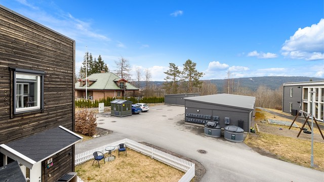 Åpent fellesområde med parkering og lekeplass
