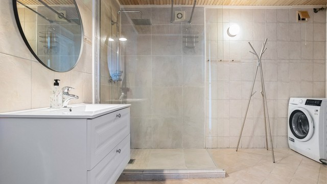 Romslig, flislagt bad med gulvvarme og opplegg for vaskemaskin.