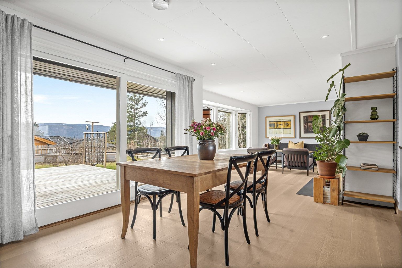 Fra spisestuen åpner store skyvedører opp mot terrassen og hagen.