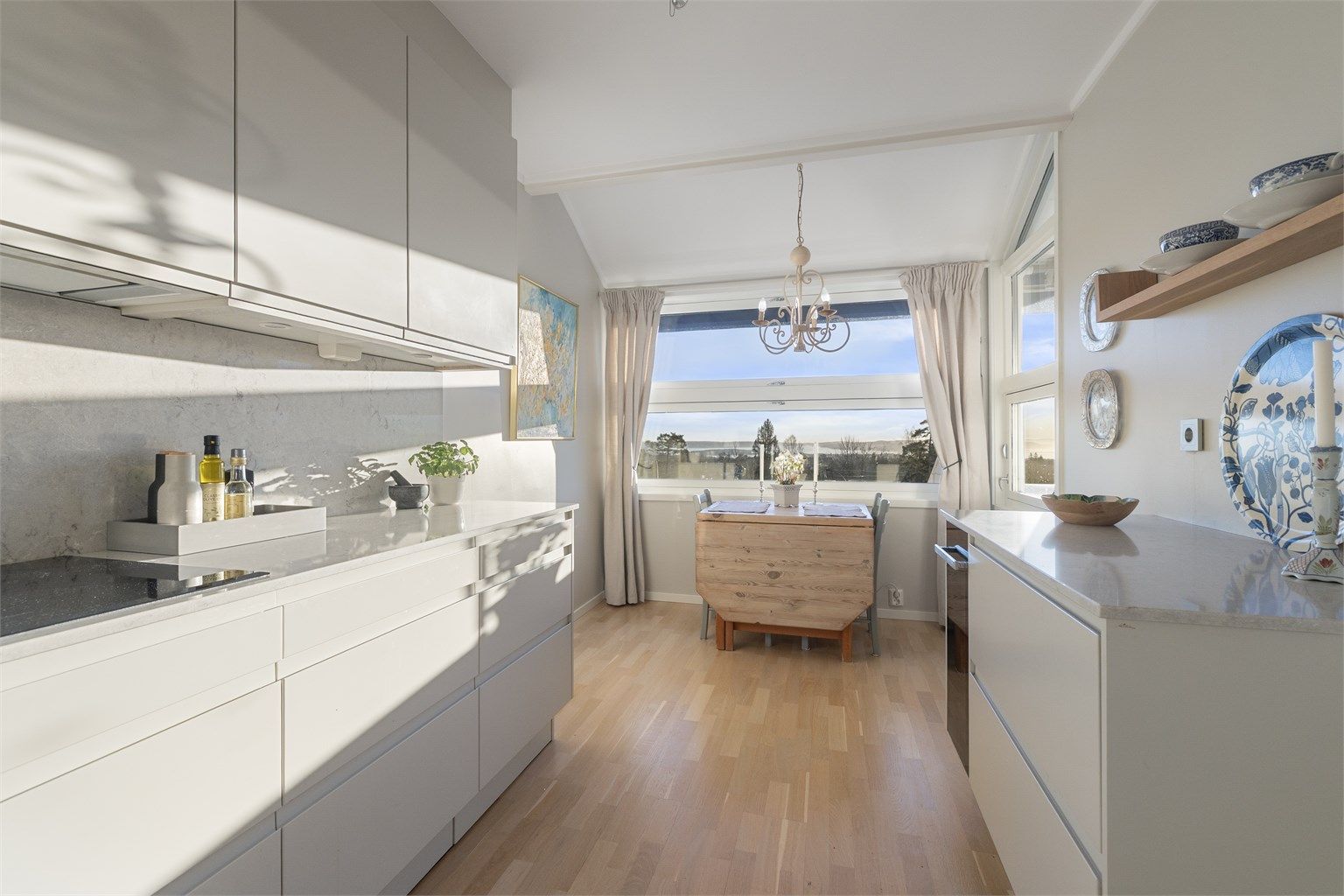 Det er flislagt mellom benkeplaten og overskapene, samt belysning og stikkontakter over benken.