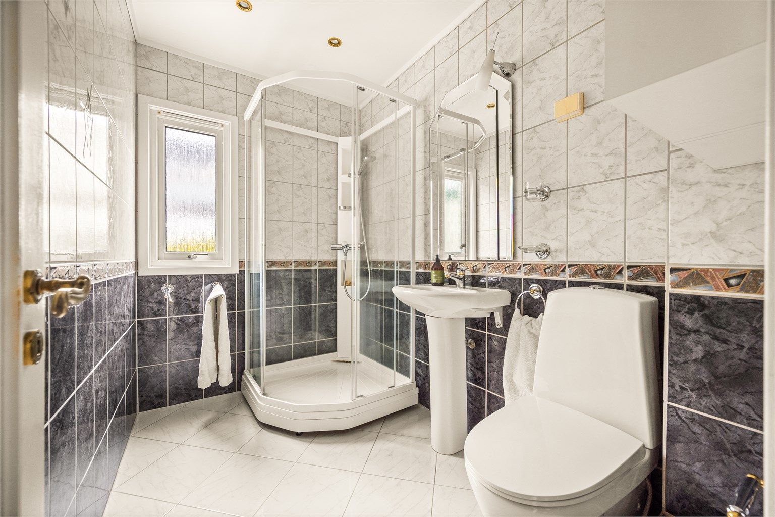 Flislagt bad med gulvvarme, downlights og dusjkabinett. Badet er fra ca. 1998 og det må påregnes fornyelse innen kort tid.