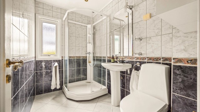 Flislagt bad med gulvvarme, downlights og dusjkabinett. Badet er fra ca. 1998 og det må påregnes fornyelse innen kort tid.