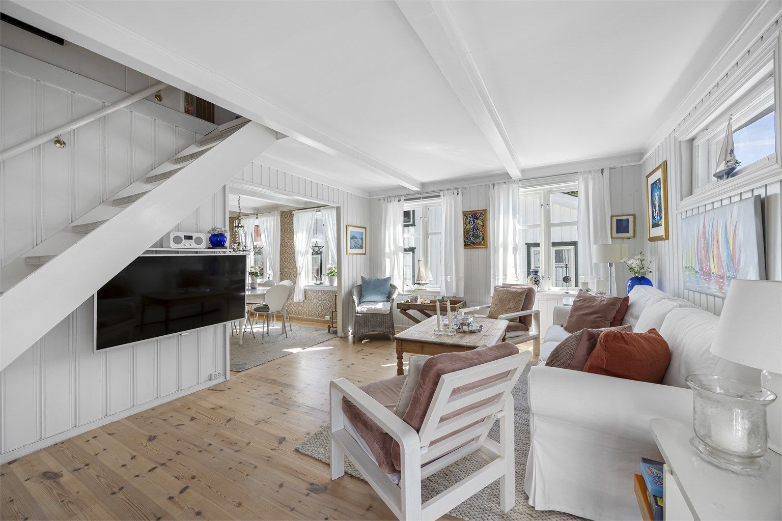 Stuen er romslig og har en åpen trapp som fører opp til loftsetasjen.