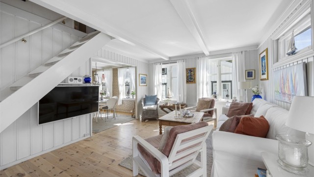 Stuen er romslig og har en åpen trapp som fører opp til loftsetasjen.