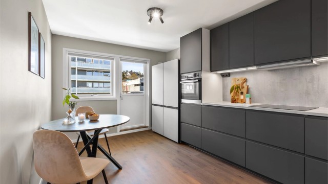 Nyoppusset, moderne kjøkken med integrerte hvitevarer og utgang til balkong. Plass til mindre spisegruppe. Foto: Trond Reder