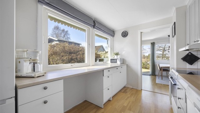 En praktisk spiseplass ved vinduet på kjøkkenet gir ekstra benkeplass og et hyggelig sted for frokosten.