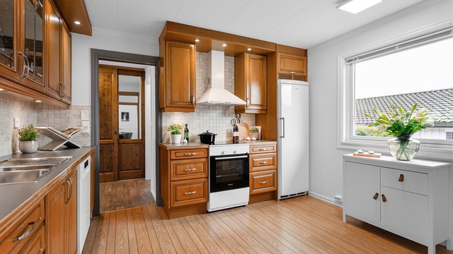 Komfyr med induksjonsplatetopp fra 2025. Oppvaskmaskin under benkeplate fra 2025. Veggmontert ventilator. Kjøleskap i nisje. Hvitevarer på kjøkkenet medfølger eiendommen.