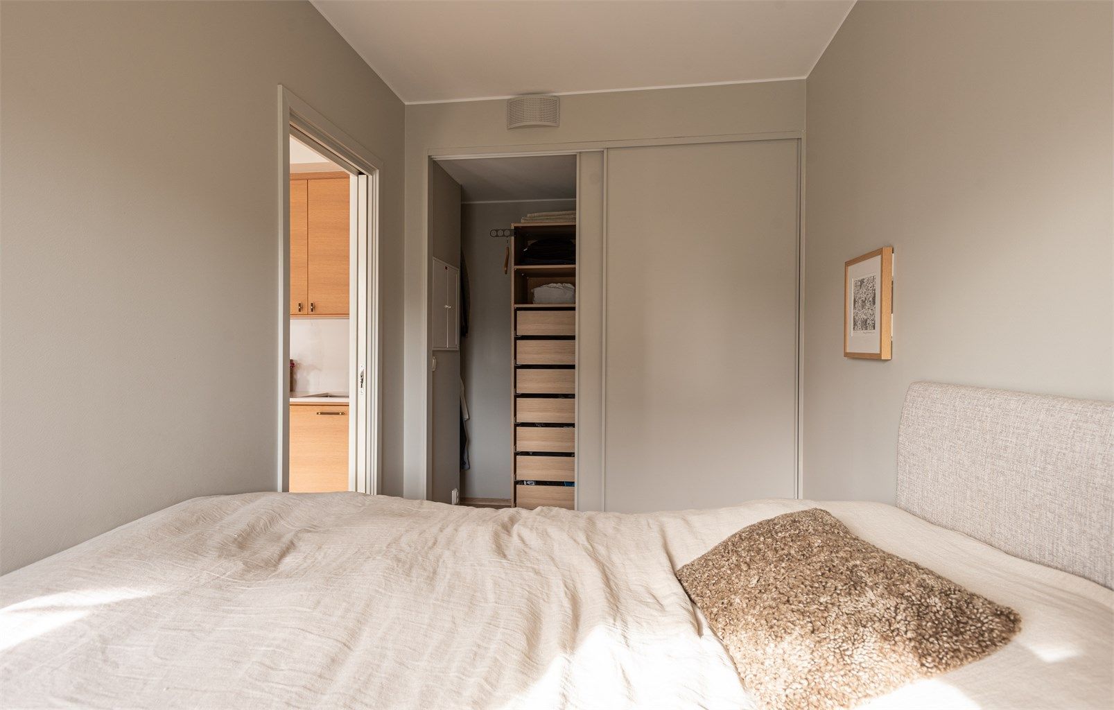 Romslig skyvedørsgarderobe med praktisk innredning av hyller og skuffer.
