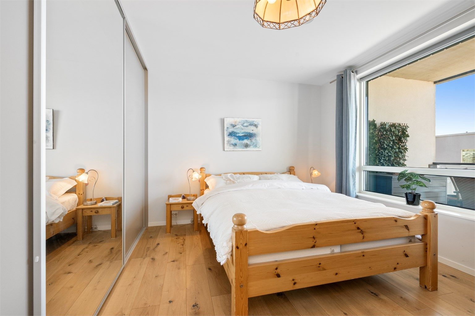 En romslig skyvedørsgarderobe med dels speilfronter gir rikelig med oppbevaringsplass