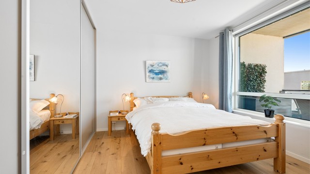 En romslig skyvedørsgarderobe med dels speilfronter gir rikelig med oppbevaringsplass