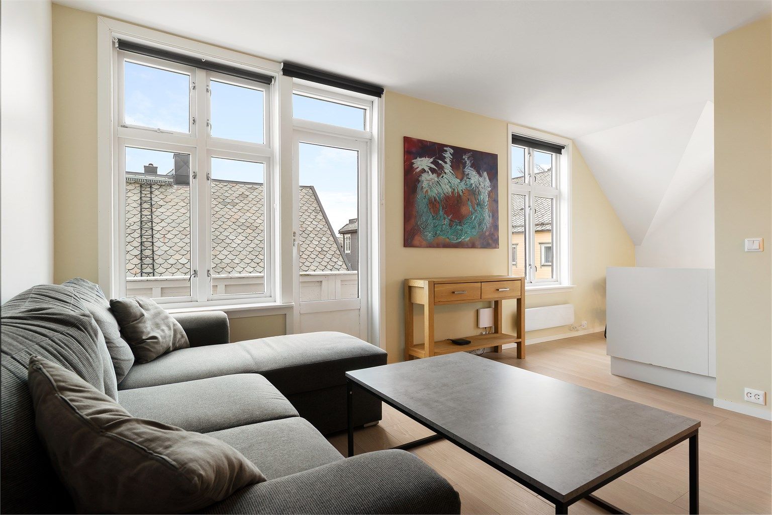 Stue med lyse overflater og åpen men likevel skjermet løsning mot kjøkken Foto: Diakrit (Krisztian Sere)