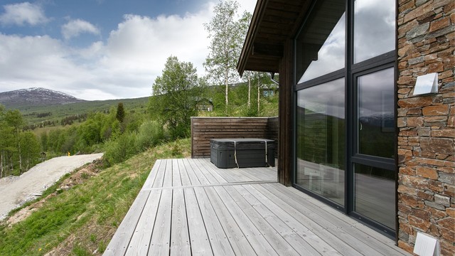 Jacuzzien er plassert avskjermet bak leveggen med utsikt mot fjellheimen.