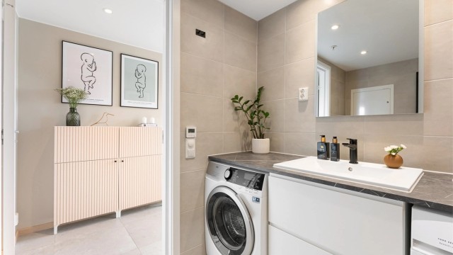 Badet er praktisk innredet med servantskap og opplegg for vaskesøyle.