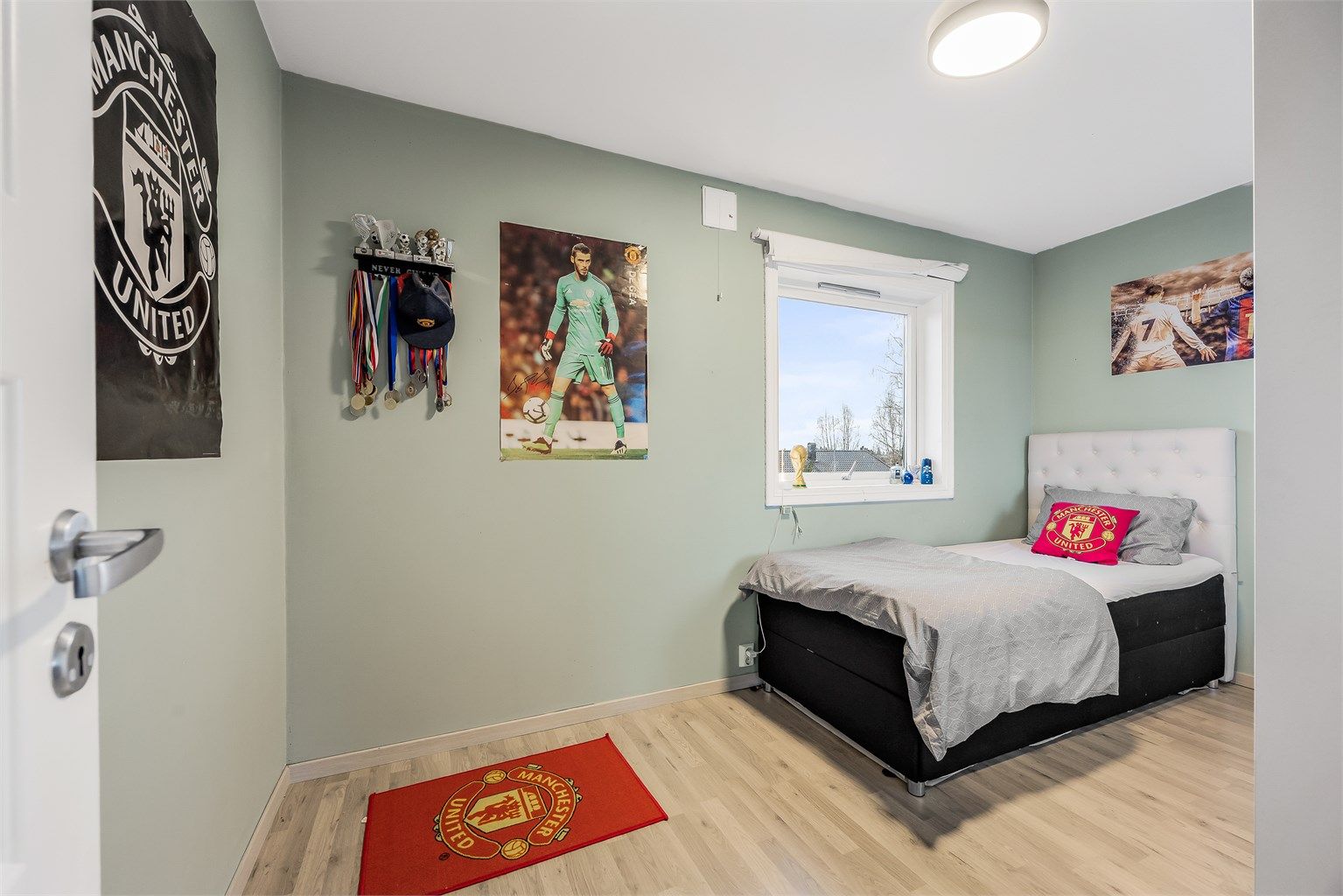 Det ene av to soverom i andre etasje, begge med laminatgulv og malte veggflater.