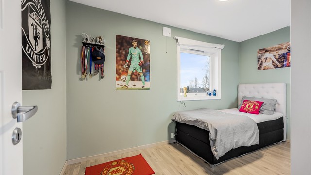 Det ene av to soverom i andre etasje, begge med laminatgulv og malte veggflater.