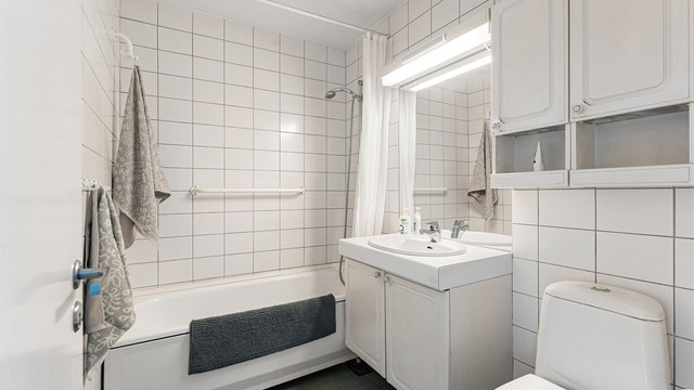 Badet i hovedetasjen er fra byggeåret, med flislagt gulv med gulvvarme og badekar.