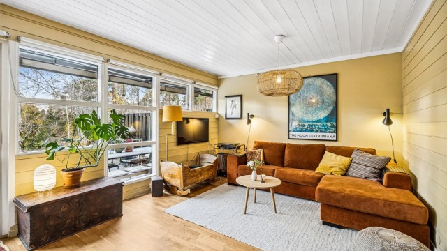 Lunt og koselig sofahjørne med utsyn mot hagen og marka – et perfekt sted for ro og avslapning.