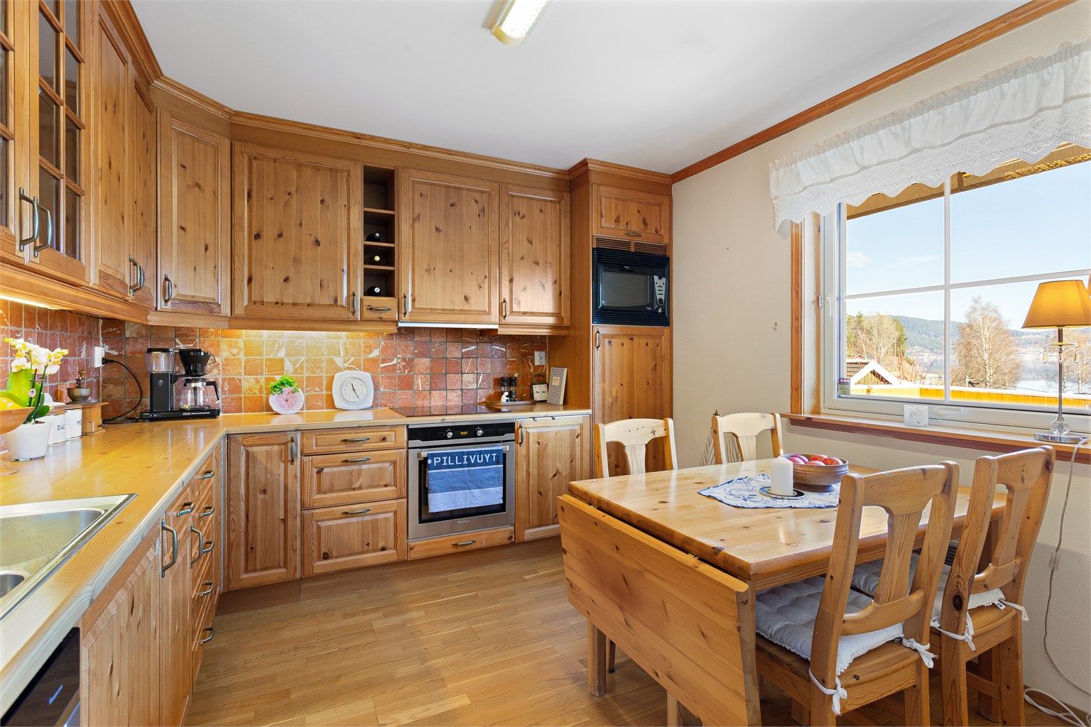 Profilert Sigdal-kjøkkeninnredning med integrerte hvitevarer.