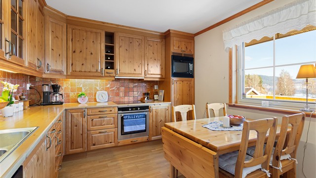 Profilert Sigdal-kjøkkeninnredning med integrerte hvitevarer.