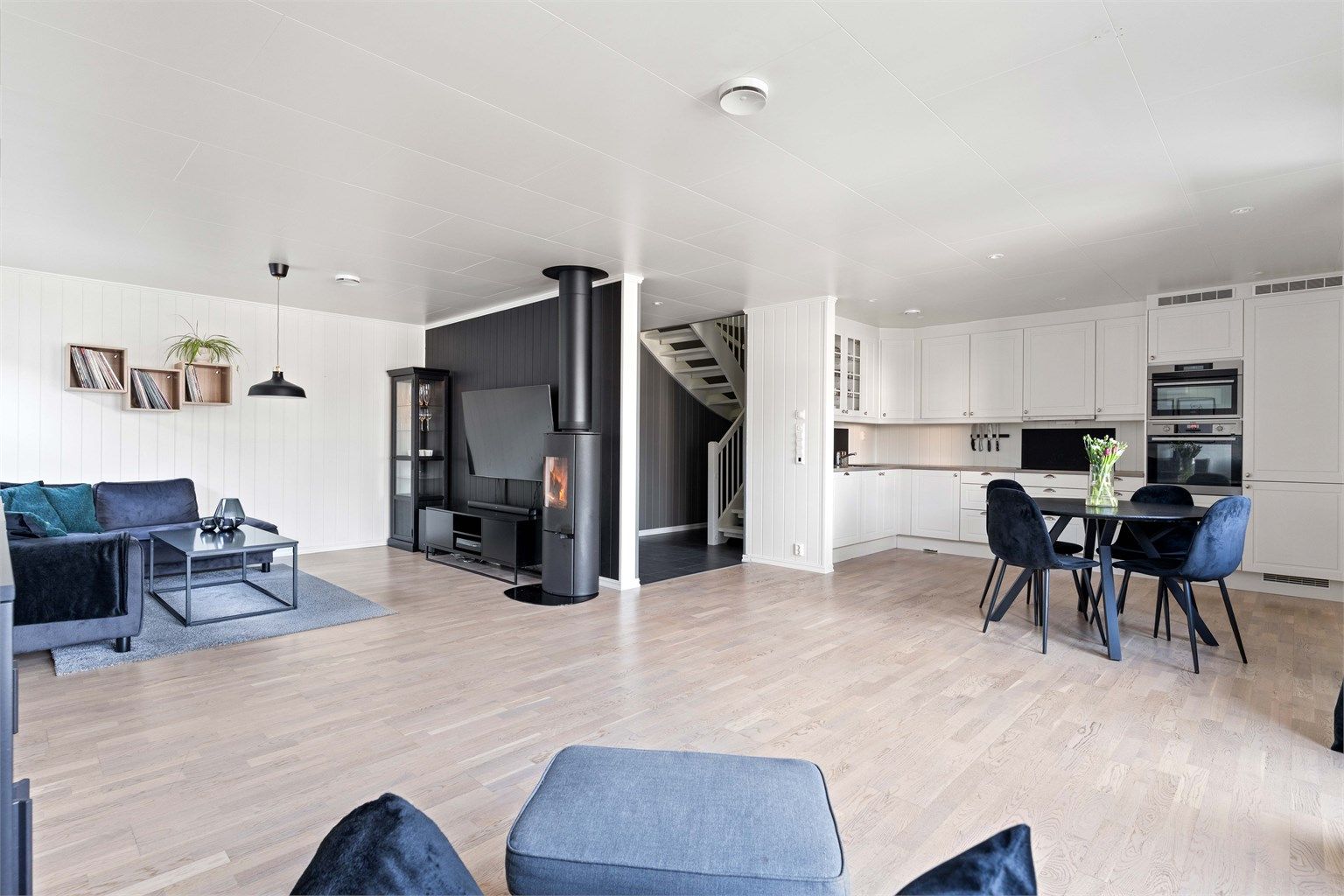 Den åpne løsningen mellom stue og kjøkken skaper en lys og luftig atmosfære.