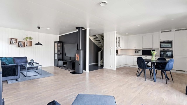 Den åpne løsningen mellom stue og kjøkken skaper en lys og luftig atmosfære.