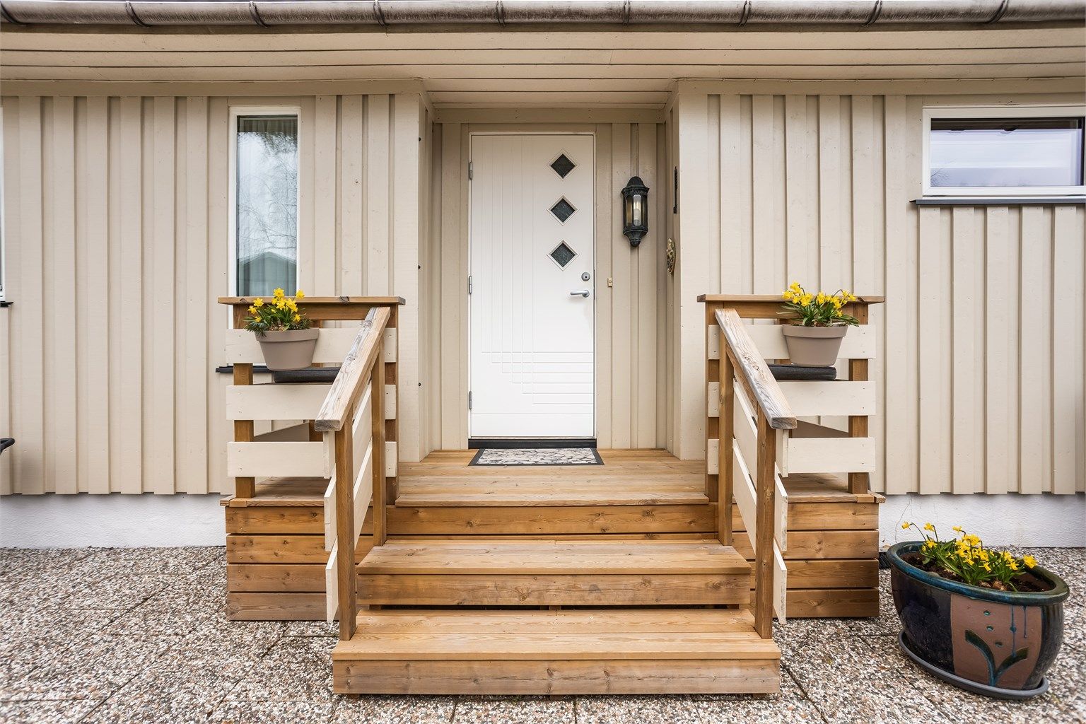 Delvis overbygget inngangsparti med en nyere ytterdør i tre.