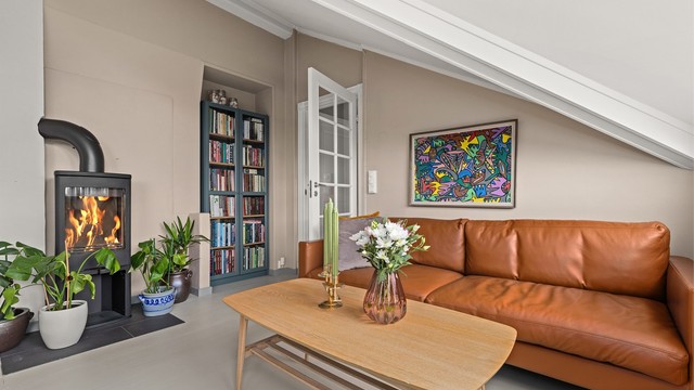 En hyggelig krok i stuen ved peisovnen, perfekt for avslapning.