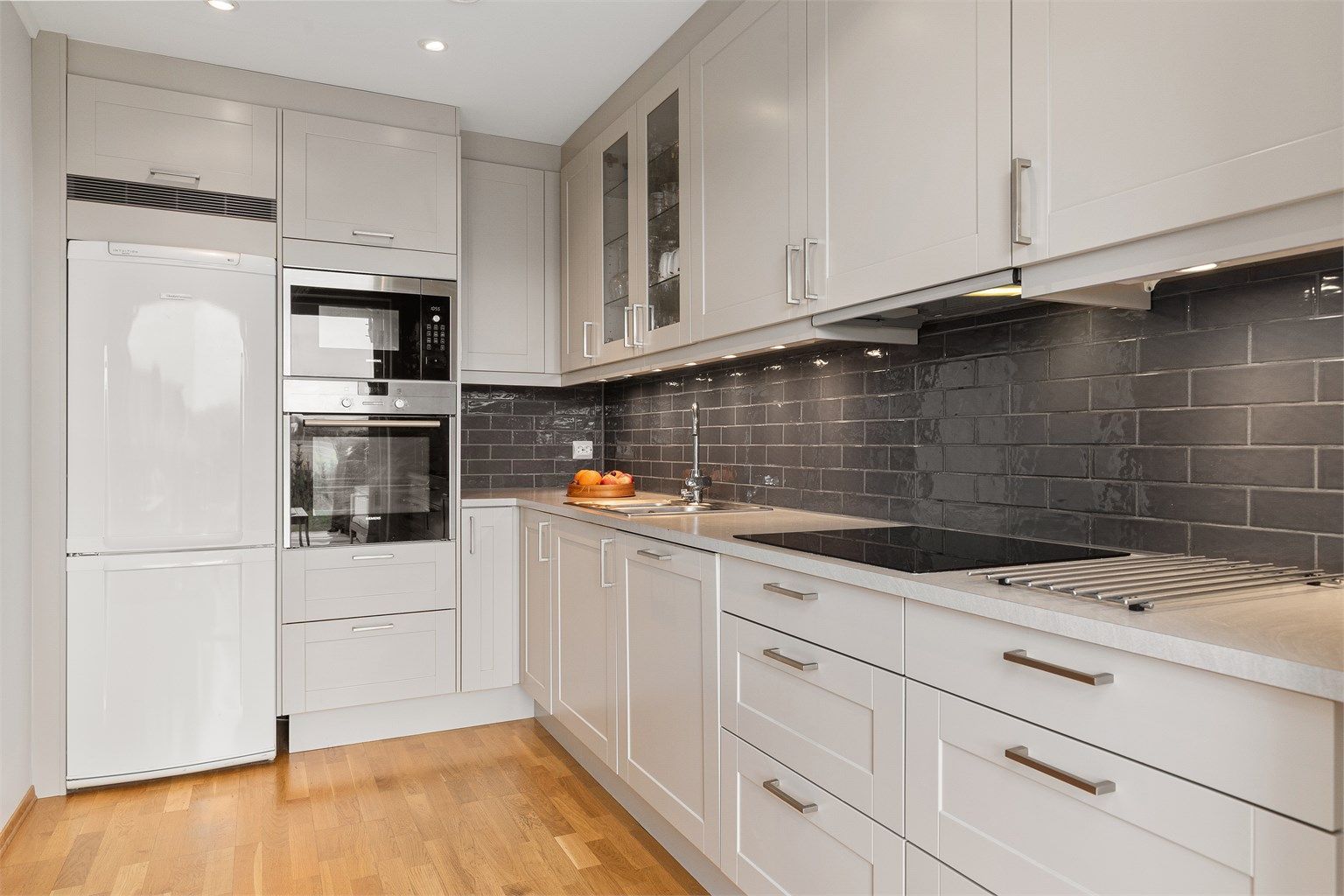 Pent og velholdt kjøkken med flere integrerte hvitevarer 