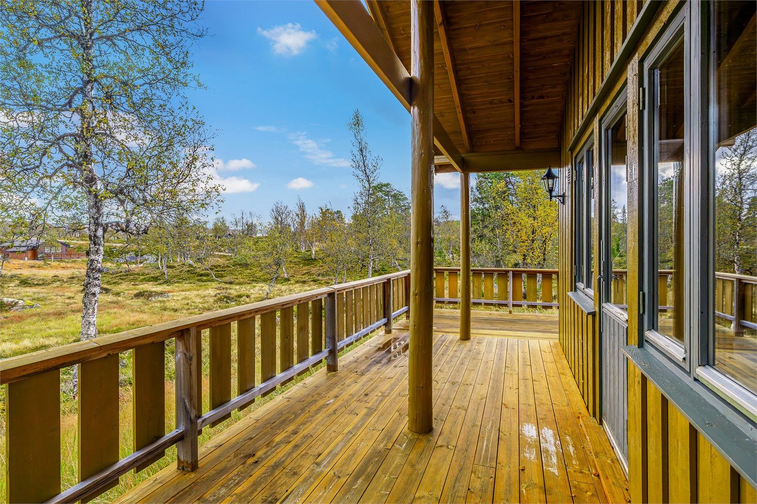 EN LUN OG HYGGELIG PLASS med overbygg ut for stua.