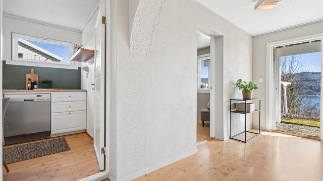 I denne etasjen finner vi også en praktisk egen inngangsdør som tar deg inn i en gang med adkomst videre inn i etasjen.