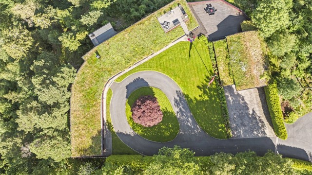 Tomten er rålekker med plen, asfaltert, privat rundkjøring, brostein og diverse beplantning, samt terrasser.