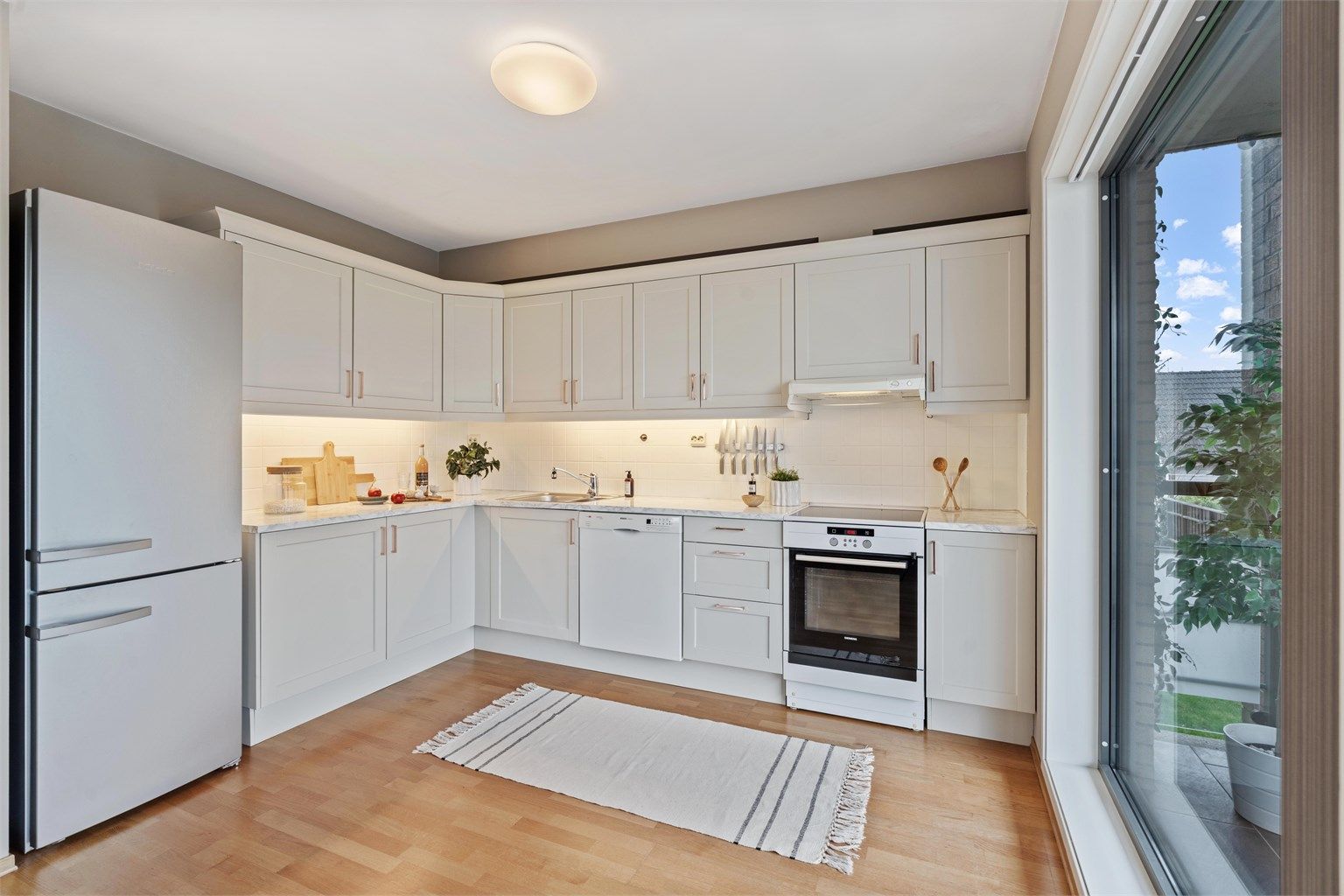 Leiligheten har en åpen og sosial planløsning mellom stue og kjøkken, med innredning fra Norema.