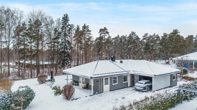 Eneboligen ligger omgitt av en lettstelt hagetomt med romslig gårdsplass med plass til flere biler i tillegg til parkering i carport