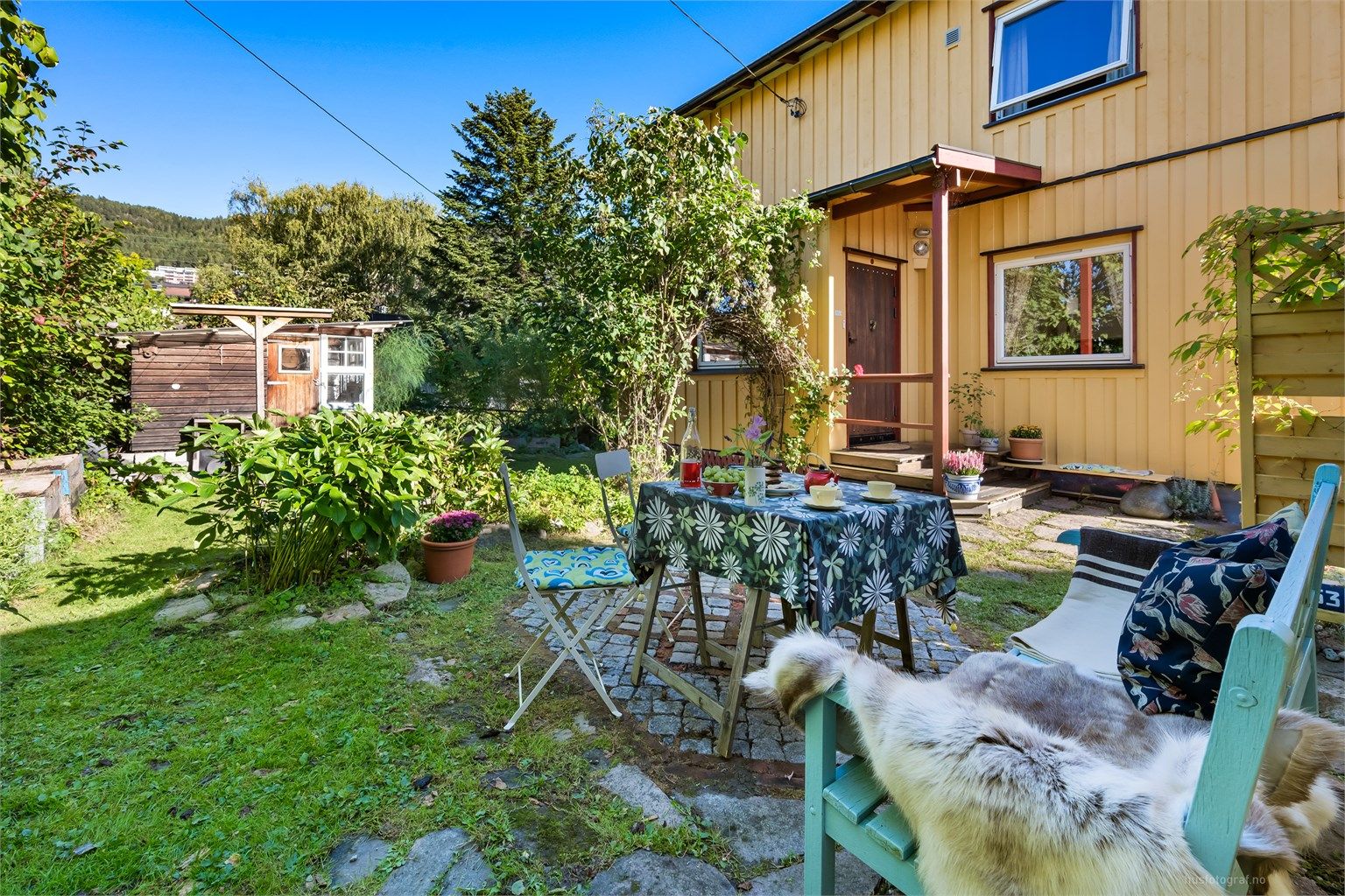 Meget sjarmerende hage med beplantninger, trær og prydbusker.