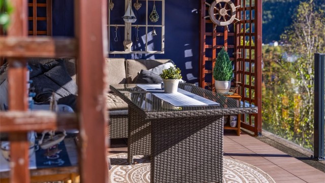 Innredet paviljong med spilevegger og plass til behagelig hjørnesofa.