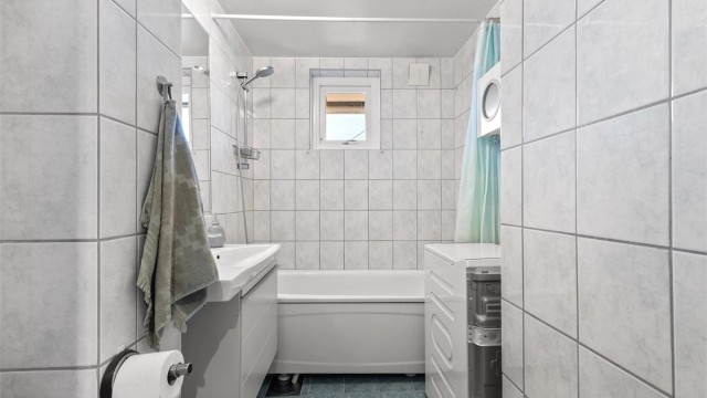 Tidløst, flislagt bad fra 2001 med varmekabler i gulvet og opplegg for vaskemaskin.