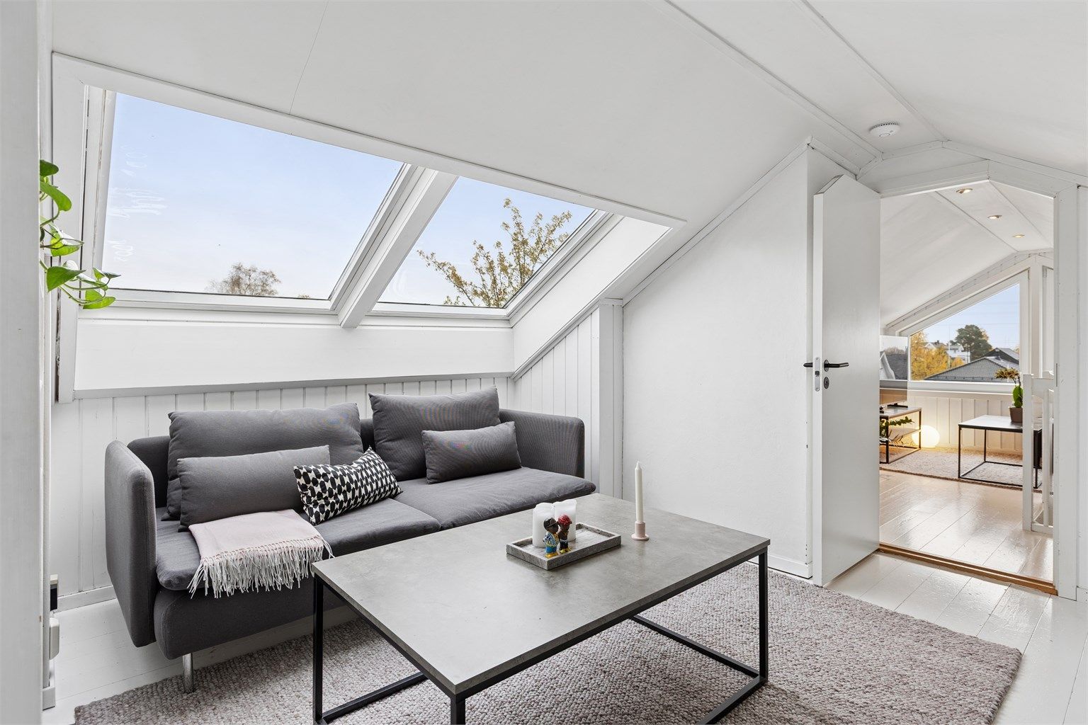 Loftstue med to Velux takvinduer og hvitmalt tregulv.