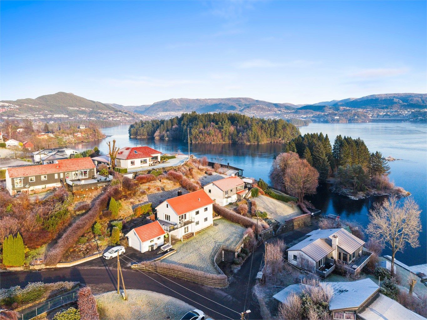 Eldre og mindre garasje på nedside av eiendommen og under plen. Nedgang til båtfeste i ende av vei.