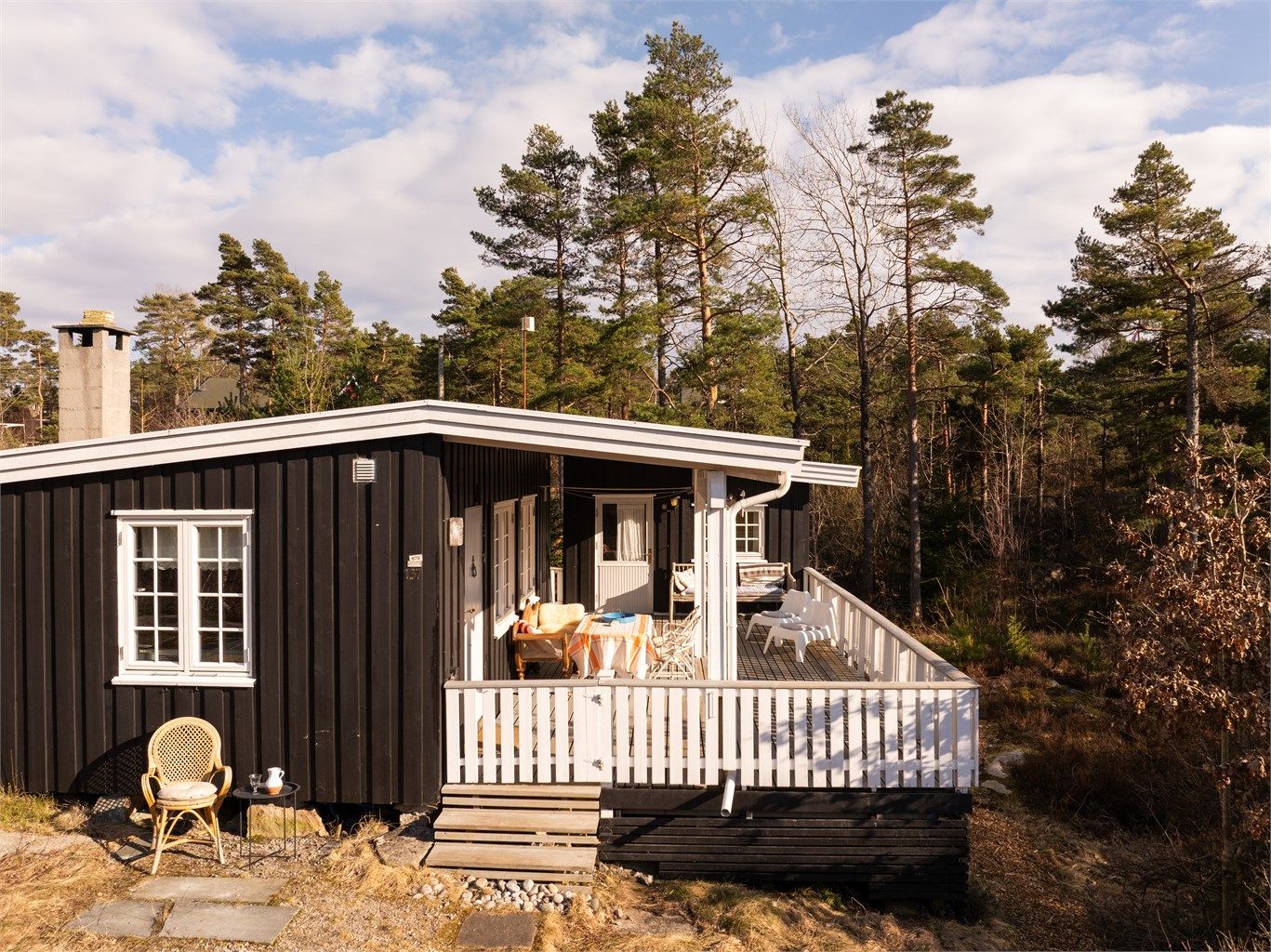 På gode sommerdager er den 40 kvm. store terrassen et prisverdig ekstra areal til hyttas indre, pent innrammet av hvitmalt rekkverk.