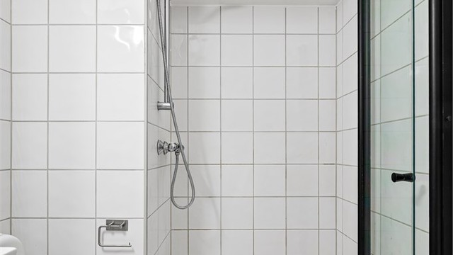 Dusjhjørne med innfellbare glassdører gir en plassbesparende og funksjonell løsning.